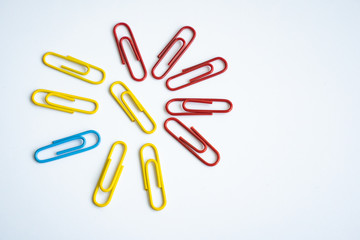 colored clips scattered on white background, form some pattern
