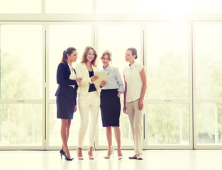 people, technology, work and corporate concept - business team of women with tablet pc computer at office
