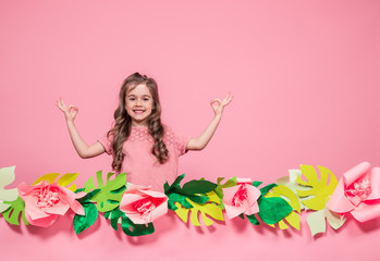 Obraz na płótnie Canvas Portrait of a little girl on a summer pink background