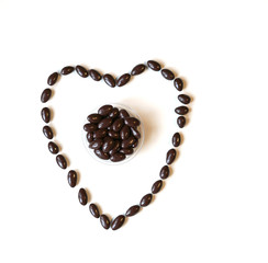 Nuts arranged in heart shape on background. Food image close up candy, chocolate milk, extra dark almond nuts. Love Texture on white grey table top view