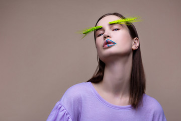 Model with blue lines on lips posing with green spikelet