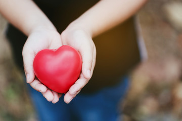 Close up of a red heart on a woman hand. It shows a love that is full of happiness. Combination of love of two people. To bring love together is a good thing to the whole world. Health care concept