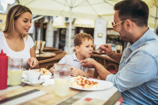 Portrait of happy family spending time in pizzeria