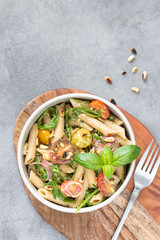 Salad - penne pasta with tomatoes, pesto, basil and lemon. Top view. Copy space. Horizontal.