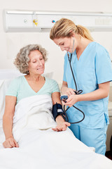 Krankenschwester beim Blutdruck messen
