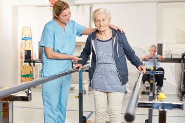 Therapeutin stützt Seniorin auf dem Laufband