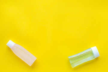 facial tonic and lotion for face care on yellow background top view mock up