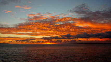 Fototapeta na wymiar spektakulärer leuchtend roter Sonnenuntergang am Meer