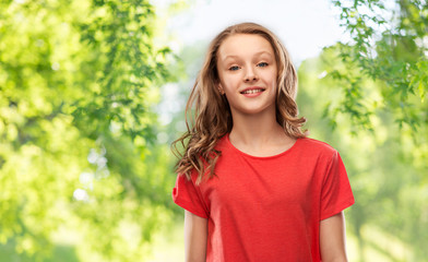 Fototapeta premium people concept - smiling teenage girl with long hair in red t-shirt over green natural background