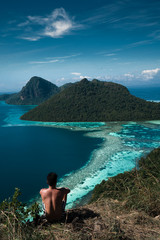 Amazing tropical paradise islands from the air with blue turquoise blue lagoon water and coral reef. Aerial view of Bohey Dulang island panorama. Hawaii, Philippines, French polynesia.

