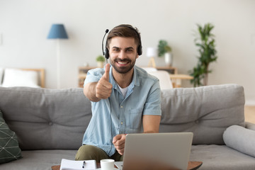 Head shot portrait happy smiling man in headset show thumbs up
