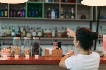 young attractive woman makes an order in a cafe