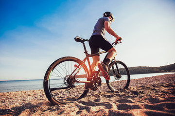 Man ride mountain bike on the beach. Sport and active life concept.