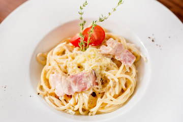 Italian pasta with bacon, tomatoes, cheese, oysters. European cuisine.