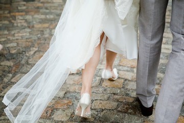 Bride and groom walking, details bride's on legs.