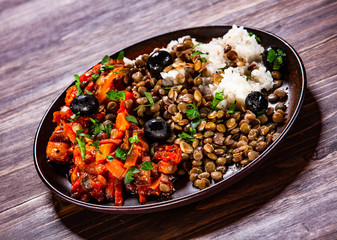 Rice with lentils and vegetables on wooden table