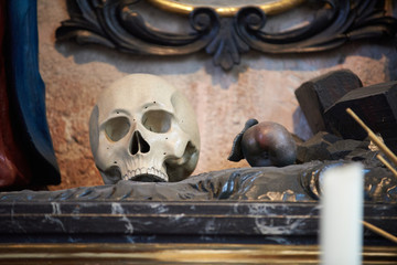 Totenkopf lehnt in einer Kirche an einer hölzernen Wand