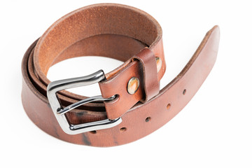 A used men's thick leather brown belt with patina from use deliberately and artistically set on a...