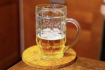 mug beer golden camp on a wooden table on a blurred background design pub. Half a beer mug