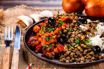Rice with lentils and vegetables on wooden table