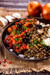 Rice with lentils and vegetables on wooden table