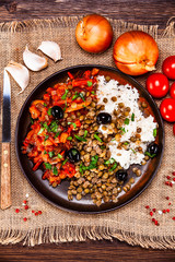 Rice with lentils and vegetables on wooden table