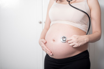  Beautiful asian pregnant woman expecting  baby with stethoscope