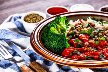 Rice with lentils and vegetables on wooden table