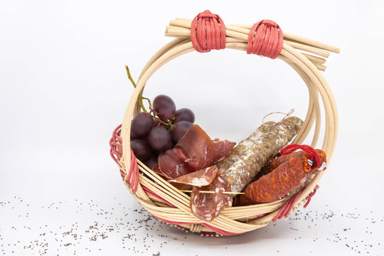 Panier de charcuterie saucisson, saucisse s&egrave;che, coppa, lonzo et chorizo et raisin rouge, dans un panier zarzo