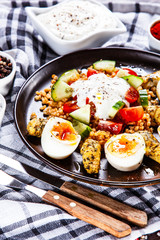 Grilled chicken meat with groats and boiled egg on wooden table