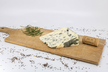 Fromage de brebis bleu d'auvergne, bleu d'aveyron, roquefort sur planche en bois à découper