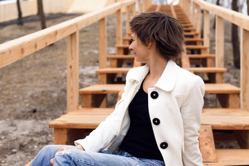 The girl shakes her head and waves her hair in the park.