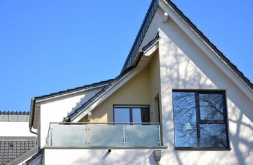 Balkon mit verglastem Edelstahl-Geländer an der Fassade eines modernen Wohnhauses