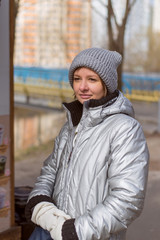 Girl 30 years old in warm clothes on the street in the park.