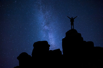 Night sky and man on peak of rock