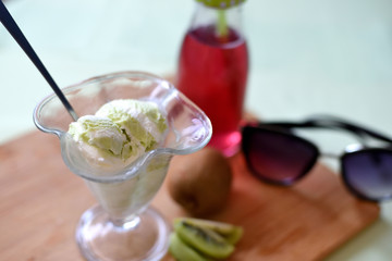 Pistachio ice cream with red juice in bottle and sunglasses, summer still life