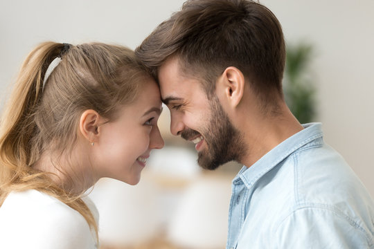 Close up smiling couple in love touching forehead, enjoying tender moment