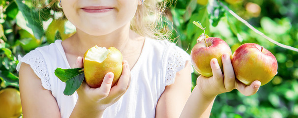 Child with an apple. Selective focus. Garden.
