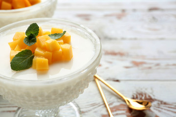Bowl of delicious panna cotta on white table