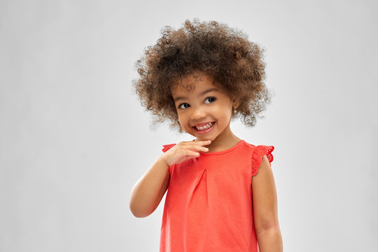childhood and people concept - happy little african american girl over grey background
