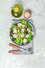 Salad with radishes over gray concrete background