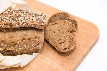 Fototapeta na wymiar dark rye bread with grains and seeds on a wooden board