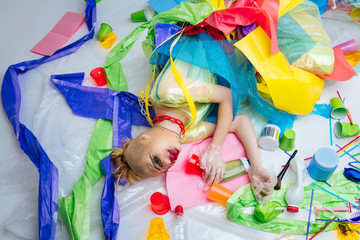 Blonde model lying on the floor with plastic trash posing