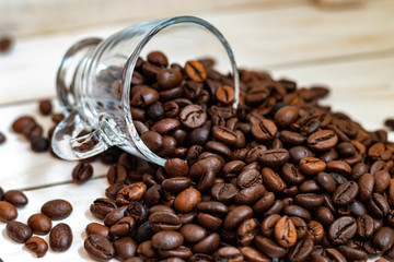 Cup and grain of coffee over white wooden background