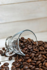 Cup and grain of coffee over white wooden background