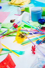 Close up of plastic cutlery and straws lying near other trash