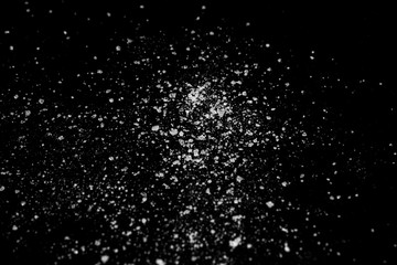 white crystalline powder on a black background. sugar dust 