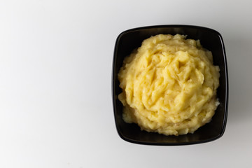 Mashed potatoes in the bowl on the white wooden table