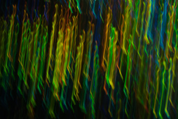 Blurry abstract background with wavy multicolor lines. Neon lights in motion. Defocused lens flare glow.