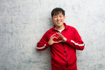 Obraz na płótnie Canvas Young sport fitness chinese doing a heart shape with hands